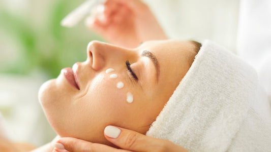 pplicazione di siero viso alla bava di lumaca su pelle di donna distesa con asciugamano bianco