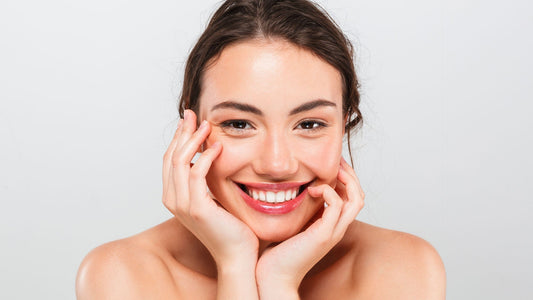 Donna sorridente che applica il siero viso alla bava di lumaca, evidenziando la differenza tra siero e crema viso per una pelle più idratata e giovane
