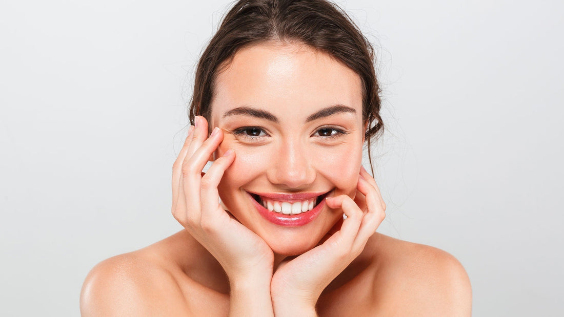 Donna sorridente che applica il siero viso alla bava di lumaca, evidenziando la differenza tra siero e crema viso per una pelle più idratata e giovane