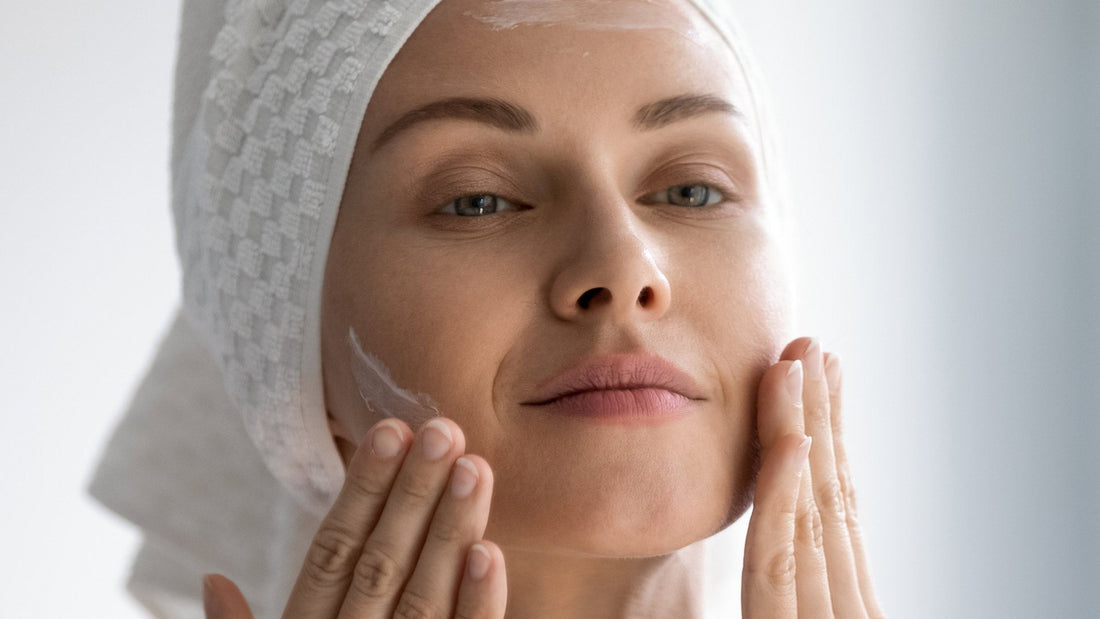 Donna che applica una crema viso in una routine antirughe alla bava di lumaca