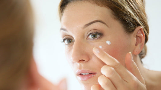Donna applica una crema viso per prendersi cura dell’elasticità della pelle