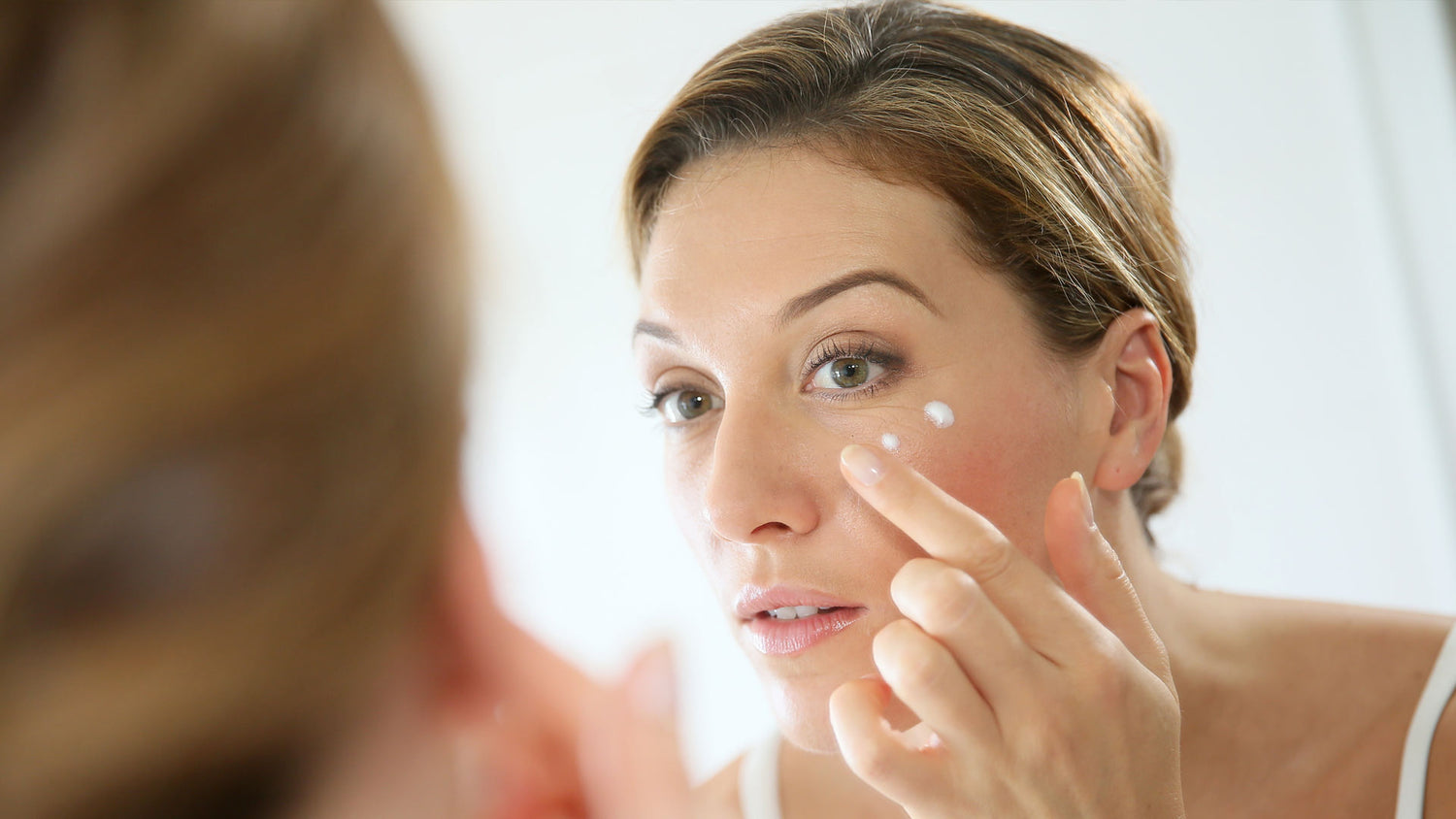 Donna applica una crema viso alla bava di lumaca naturale