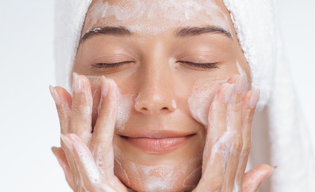 Donna che utilizza una mousse detergente alla bava di lumaca per la pulizia del viso